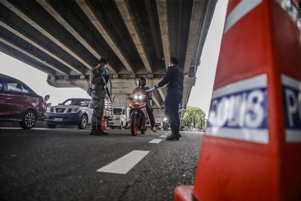 Police and Armed Forces personnel conduct checks on vehicles at a roadblock at Bandar Sri Menjalara June 1, 2021. — Picture by Hari Anggara