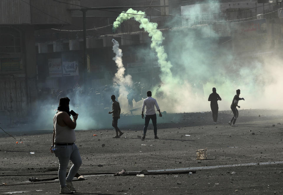 Iraqi security forces fire tear gas during clashes with anti-government protesters, in Baghdad, Iraq, Monday, Nov. 11, 2019. (AP Photo/Hadi Mizban)