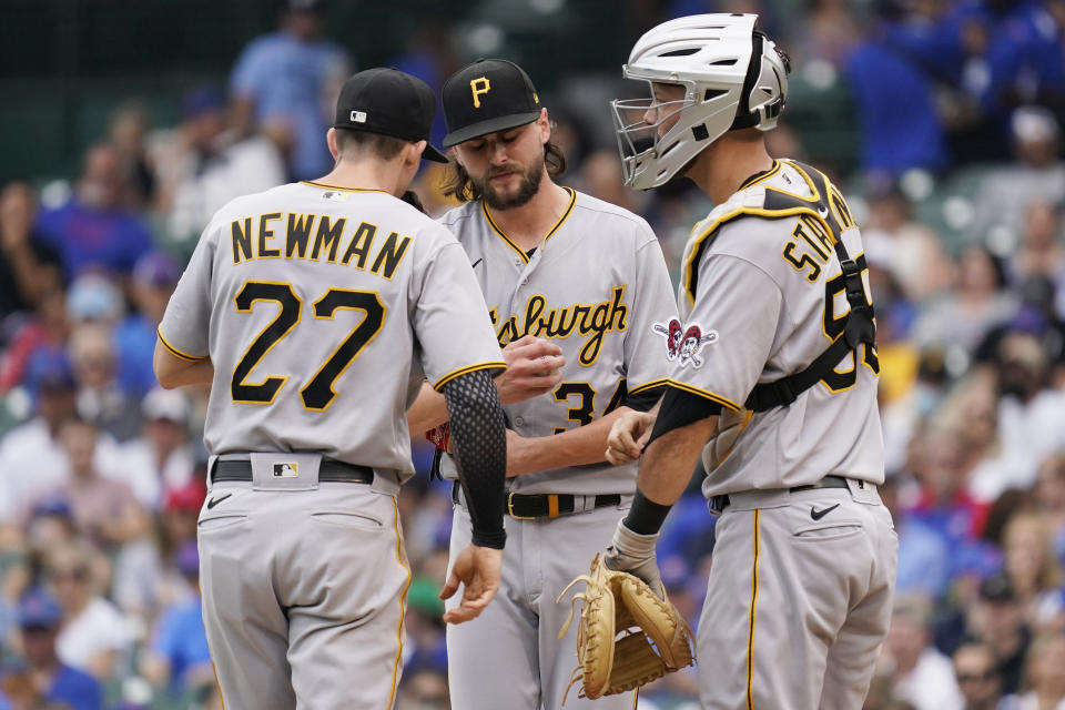 Pittsburgh Pirates starting pitcher JT Brubaker, center, reacts as he talks with shortstop Kevin Newman, left, and catcher Jacob Stallings during the fourth inning of a baseball game against the Chicago Cubs in Chicago, Saturday, Sept. 4, 2021. (AP Photo/Nam Y. Huh)