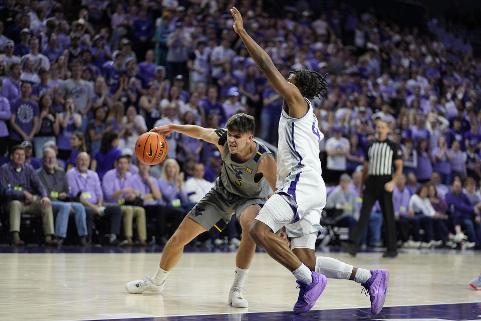 West Virginia guard Kerr Kriisa (3) tries to get past Kansas State guard Dai Dai Ames (4) during the first half of an NCAA college basketball game Monday, Feb. 26, 2024, in Manhattan, Kan. (AP Photo/Charlie Riedel)