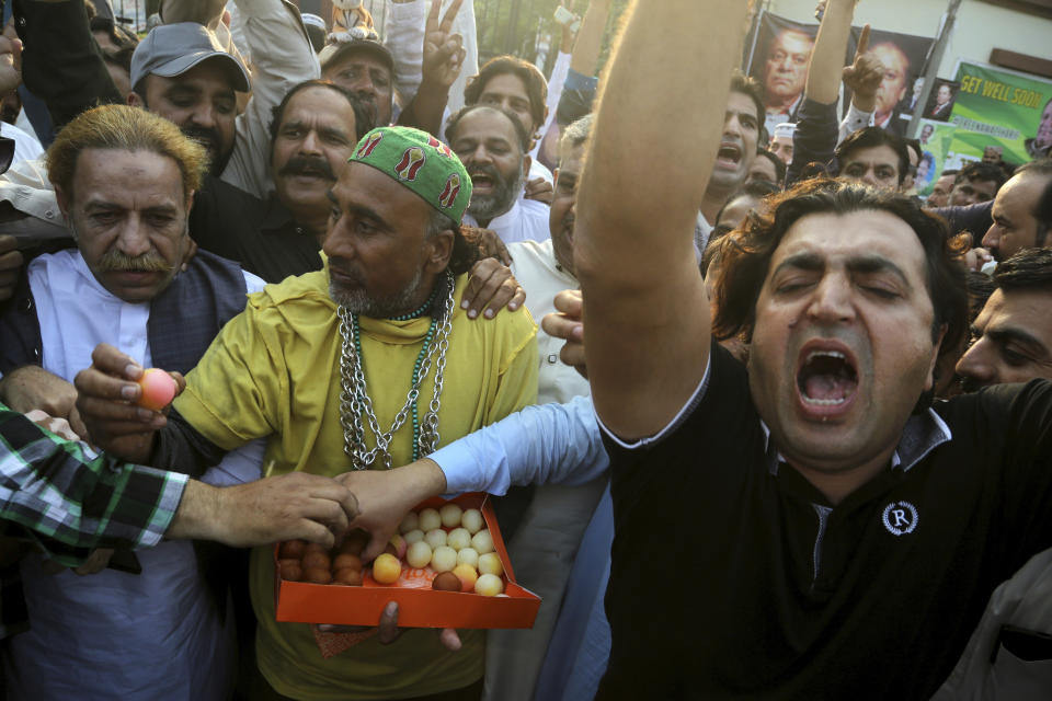 Supporters of Pakistani former Prime Minister Nawaz Sharif celebrate the release of their leader, outside a hospital where Sharif admitted in Lahore, Pakistan, Friday, Oct. 25, 2019. A top Pakistani court on Friday ordered convicted former Sharif released on bail so he can seek medical treatment at home or abroad, his family and a defense lawyer said. (AP Photo/K.M. Chaudary)