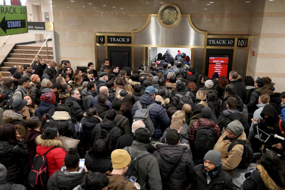 Homebound NJ Transit commuters squeeze through a gate as they make their way to a train at Penn Station during the evening commute Jan. 22, 2020. After crowding under train schedule boards waiting for gate locations to be posted, commuters rush to their gates, with sometimes only minutes to spare before their train leaves the station.