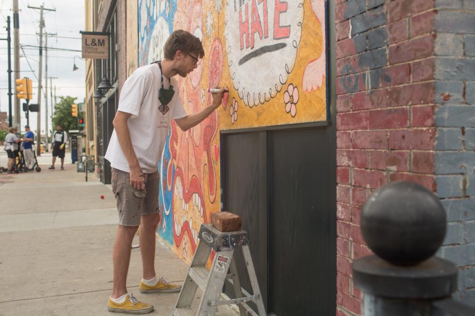 Artist Greg Stivers works on a mural in downtown Tulsa on June 20, 2020.