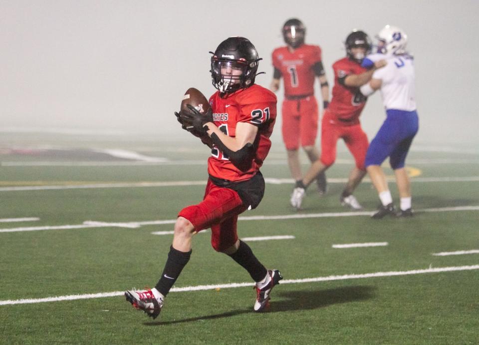 Nolan Carruthers of Pinckney pulls in a pass from Brady Raymond (1) and runs it in for one of his two touchdowns in a 28-13 loss to Adrian on Friday, Sept. 30, 2022.