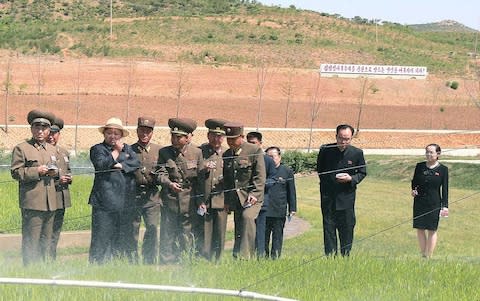 Kim Yo-jong seen on the right during a visit by her brother to a tree nursery in a photo released in 2015 - Credit: AFP PHOTO via Korean Central News Agency