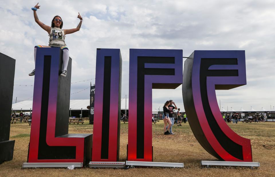 Lorena Coleman climbed up on the Louder Than Life letters at the 2022 Louder Than Life on Saturday.  Sept. 24, 2022