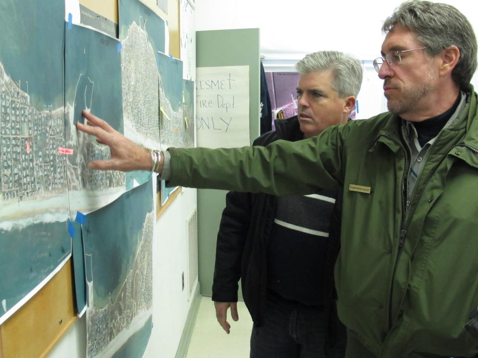 In this Friday, Nov. 16, 2012 photo, Chris Soller, right, superintendent of the Fire Island National Seashore, points to a map of Fire Island with Suffolk County Executive Steve Bellone, in Kismet, N.Y. The two were among a team of officials touring the damaged barrier island south of Long Island. (AP Photo/Frank Eltman)