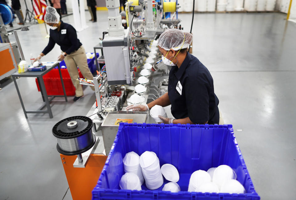 Workers gather N95 masks as they come off an assembly line (John Tlumacki / Boston Globe via Getty Images file)