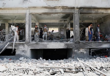 Afghan security forces inspect a damaged building at the site of a blast in Kabul, Afghanistan