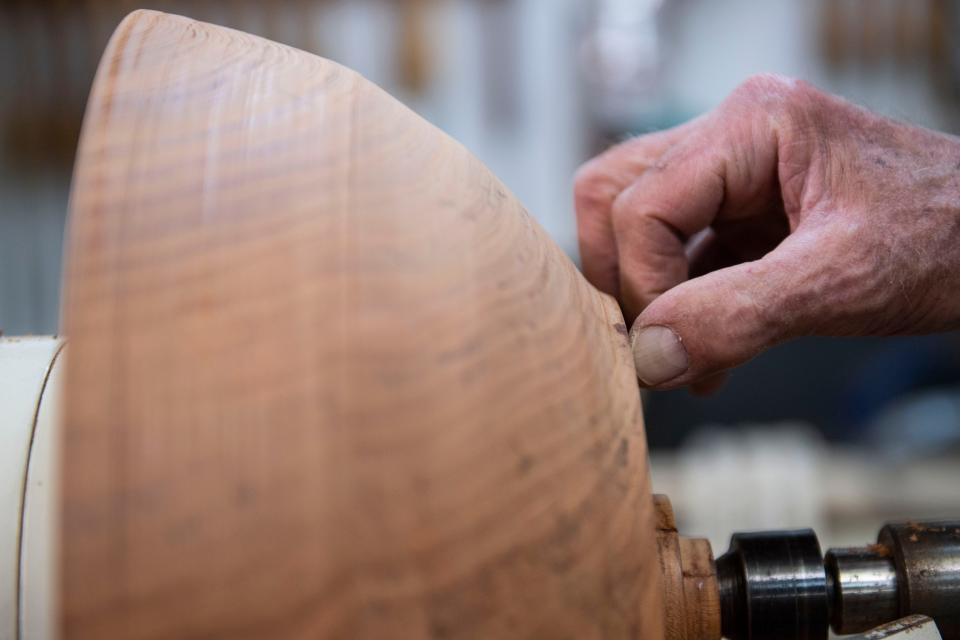 Michael McDunn, Open Studios participant, checks a carved wooden bowl for cracks in his studio in Greenville on Wednesday, Oct. 26, 2022. 