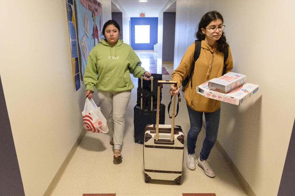 University of New Haven students Victoria Salazar and Alexis Cervantes (from left) leave their nearly deserted residence hall room with bags packed after the campus closed due to coronavirus concerns on March 11, 2020. California natives, the two planned to live in a hotel until a flight they booked for their spring break will bring them home. (Mark Mirko/Hartford Courant/Tribune News Service via Getty Images)