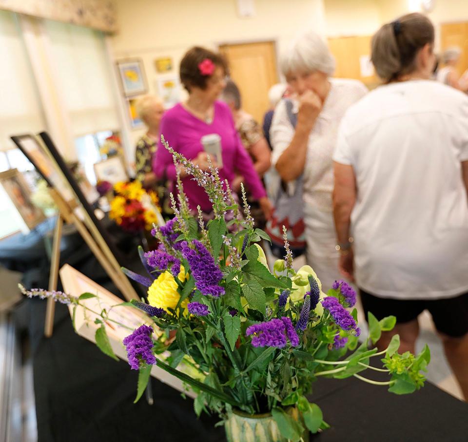 "Art in Bloom" brings local florists and artists together. Members of the Seaside Gardeners, a local club, recreate works of art by students at the Marshfield Senior Center through flower arrangements.