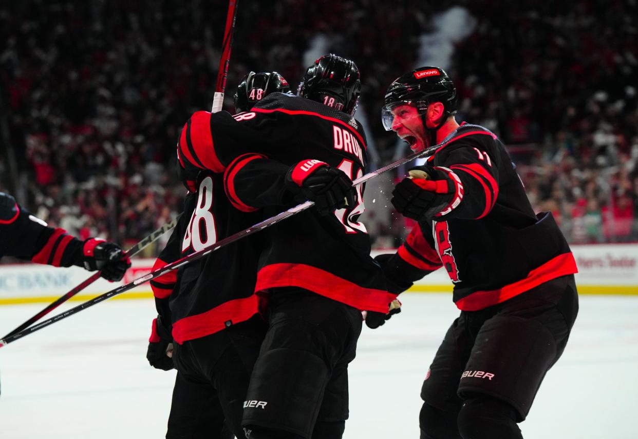 Carolina Hurricanes left wing Jordan Martinook (48) is congratulated by center Jack Drury (18) and center Jordan Staal (11) after his third-period goal against the New York Islanders.