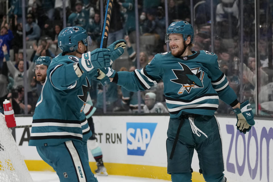 San Jose Sharks left wing Evgeny Svechnikov, right, is congratulated by center Nico Sturm (7) after scoring against the Seattle Kraken during the second period of an NHL hockey game in San Jose, Calif., Monday, Feb. 20, 2023. (AP Photo/Jeff Chiu)