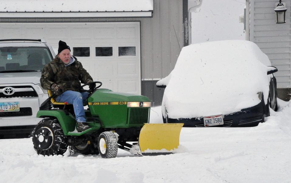 A resident in the Guerne area pushes the snow out of the way on Monday morning.