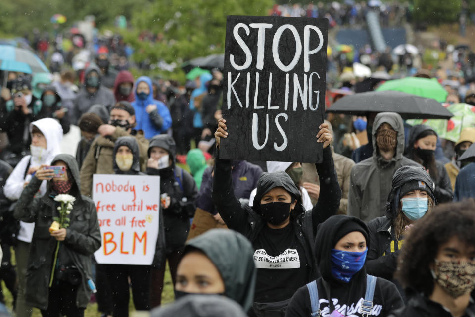 A protester holds a sign that reads "Stop Killing Us" during a "Silent March" against racial inequality and police brutality that was organized by Black Lives Matter Seattle-King County, Friday, June 12, 2020, in Seattle. People marched for nearly two miles to support Black lives, oppose racism and to call for police reforms among other issues. (AP Photo/Ted S. Warren)