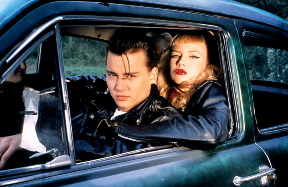 Johnny Depp and Traci Lords in 'Cry-Baby,' dressed in 50s style, sitting in a vintage car