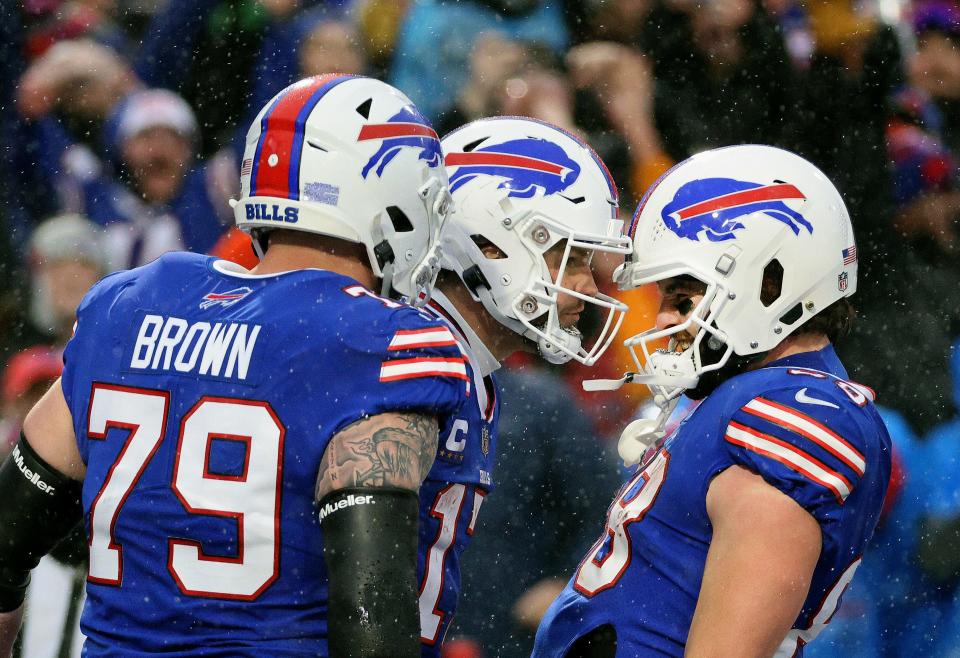 Bills quarterback Josh Allen celebrates his touchdown run with Dawson Knox and Spencer Brown. 