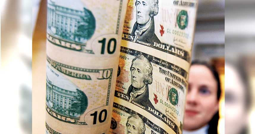 一名女記者在觀看新版10美元鈔票的水印（圖／新華社）