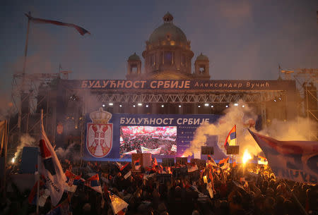 Supporters of Serbian President Aleksandar Vucic burn flare as they wait for his arrival for his campaign rally "The Future of Serbia" in front of the Parliament Building in Belgrade, Serbia, April 19, 2019. REUTERS/Marko Djurica. The Banner reads: "The future of Serbia".