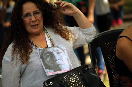 A woman shows a portrait of Milagro Sala, the leader of the Tupac Amaru social welfare group, as supporters hear Sala's trial in San Salvador de Jujuy, with charges ranging from intimidation to corruption, on a radio outside a Justice building in Buenos Aires, Argentina, December 28, 2016. REUTERS/Marcos Brindicci