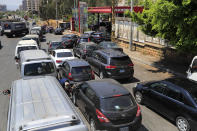 Cars and mini buses wait in a long queue for gasoline, in Beirut, Lebanon, Friday, June 25, 2021. Lebanon's caretaker prime minister on Friday granted his approval to allow the financing of fuel imports at a rate higher than the official exchange rate, effectively reducing critical fuel subsidies that have been in place for decades, amid worsening gasoline shortages. (AP Photo/Hussein Malla)