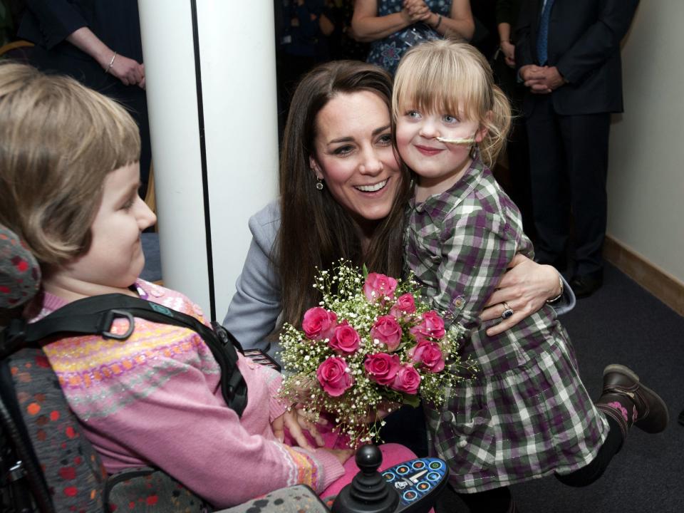 Kate Middleton hugs a girl at Shooting Star House Children's Hospice in 2013.