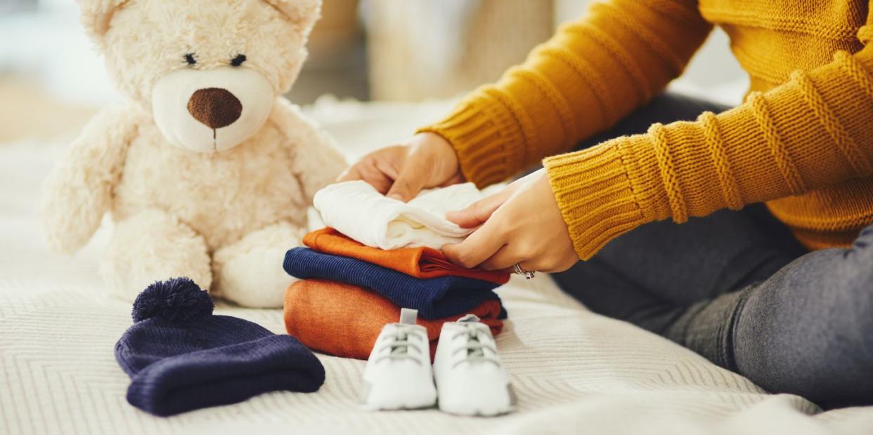 woman folding baby clothes