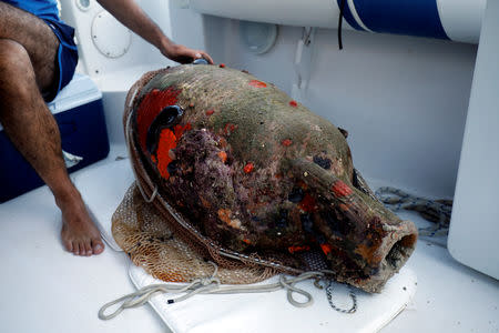 Chief conservator of the Fournoi Survey Project Angelos Tsompanidis, 42, inspects an amphora retrieved from a shipwreck site on the island of Fournoi, Greece, September 19, 2018. Picture taken September 19, 2018. REUTERS/Alkis Konstantinidis