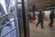 FILE - Police patrol the A line subway train bound to Inwood, Saturday Feb. 13, 2021, in New York. The worldwide surge in coronavirus cases driven by the new omicron variant is the latest blow to already strained hospitals, nursing homes, police departments and supermarkets struggling to maintain a full contingent of nurses, police officers and other essential workers as the pandemic enters its third year. (AP Photo/Bebeto Matthews, File)