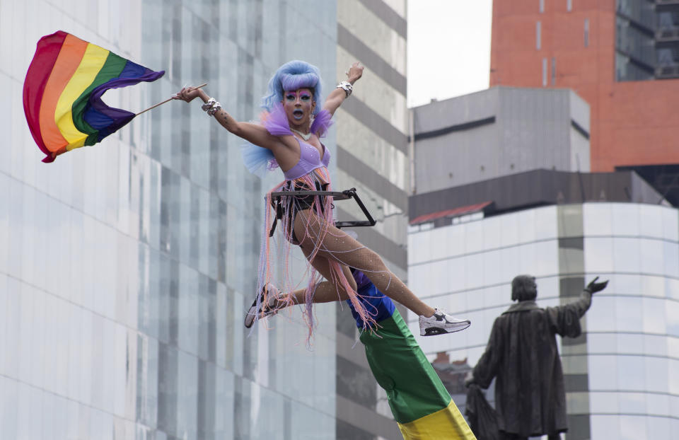 A performer flies a rainbow flag during the gay pride parade, in Mexico City, Saturday, Jun. 29, 2019. (AP Photo/Christian Palma)