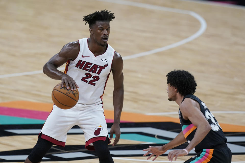 Miami Heat forward Jimmy Butler (22) drives around San Antonio Spurs guard Tre Jones (33) during the second half of an NBA basketball game in San Antonio, Wednesday, April 21, 2021. (AP Photo/Eric Gay)