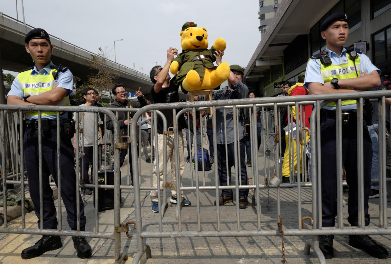 FILE - Protesters raise a Winnie the Pooh dressing as a Communist Party member to symbolise Chinese President Xi Jinping, in Hong Kong Sunday, March 18, 2018, during a protest on an amendment to China's constitution that will abolish term limits on the presidency and enable Xi to rule indefinitely. Public screenings of a slasher film that features Winnie the Pooh were scrapped abruptly in Hong Kong on Tuesday, March 21, 2023 sparking discussions over increasing censorship in the city. For many residents, the Winnie the Pooh character is a playful taunt of China's President Xi Jinping, and Chinese censors in the past had briefly banned social media searches for the bear in the country. (AP Photo/Vincent Yu, File)