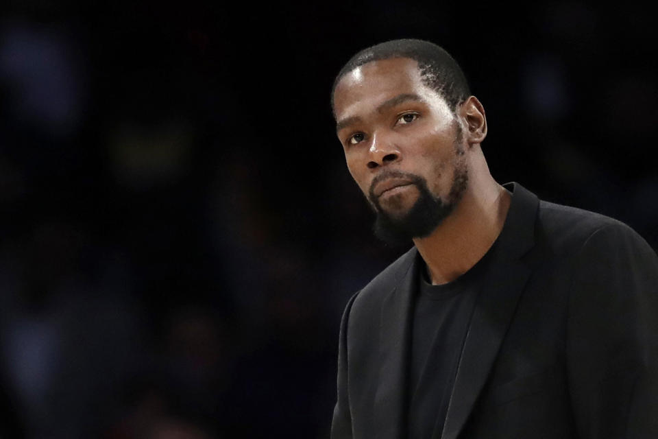 Kevin Durant watches during the second half of the team's NBA basketball game against the Los Angeles Lakers in Los Angeles. Kevin Durant is finally within weeks of suiting up for the Brooklyn Nets. Sidelined last season while recovering from surgery on his Achilles tendon, he begins training camp this week on a team that can contend for the NBA title if he can be as good as he was before his injury. (AP Photo/Marcio Jose Sanchez, file)