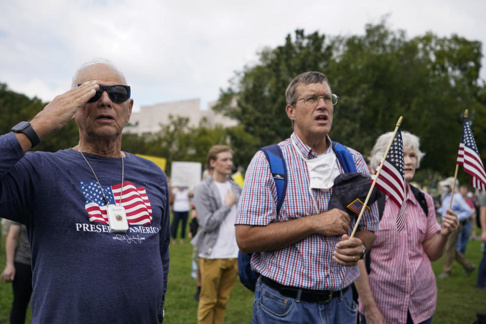 People stand as the national anthem plays during a rally near the U.S. Capitol in Washington, Saturday, Sept. 18, 2021. The rally was planned by allies of former President Donald Trump and aimed at supporting the so-called "political prisoners" of the Jan. 6 insurrection at the U.S. Capitol. (AP Photo/Brynn Anderson)