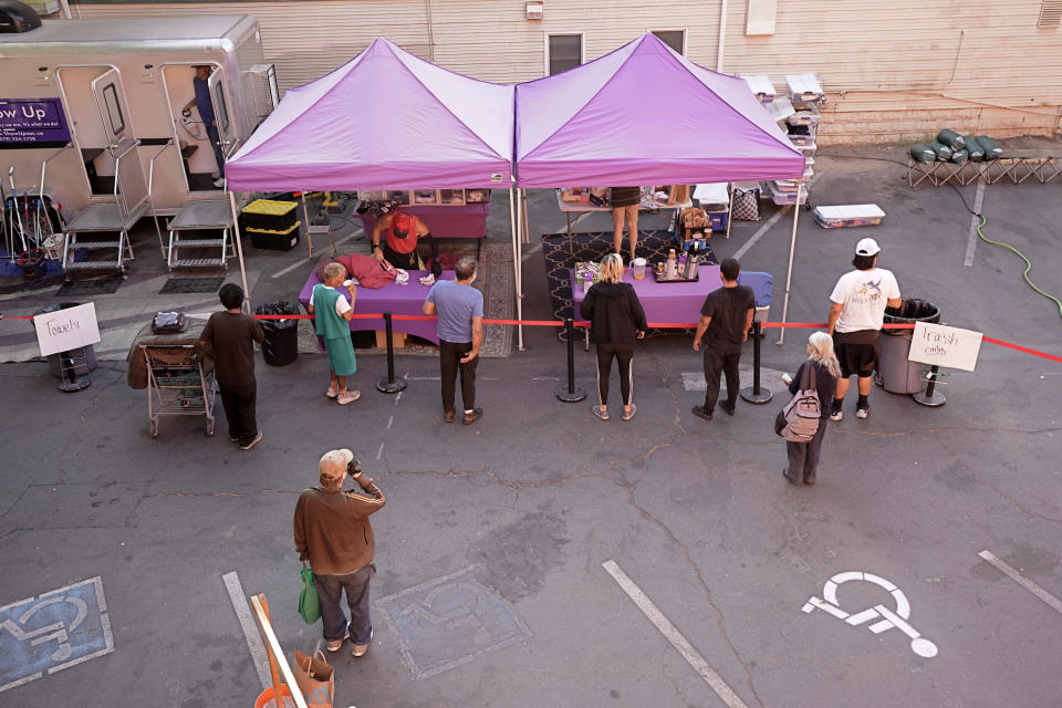 People line up for food and and other help at ShowUp Sac in Sacramento, Calif., Tuesday, Aug. 16, 2022. ShowUp Sac is a nonprofit that provides food, clothing and showers to people experiencing homelessness. Sacramento County had more than 9,200 people experiencing homelessness during this year's annual count, conducted in February. (AP Photo/Rich Pedroncelli)