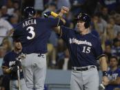 Milwaukee Brewers' Orlando Arcia celebrates his two-run home run with Erik Kratz (15) during the seventh inning of Game 3 of the National League Championship Series baseball game against the Los Angeles Dodgers Monday, Oct. 15, 2018, in Los Angeles. (AP Photo/Jae Hong)