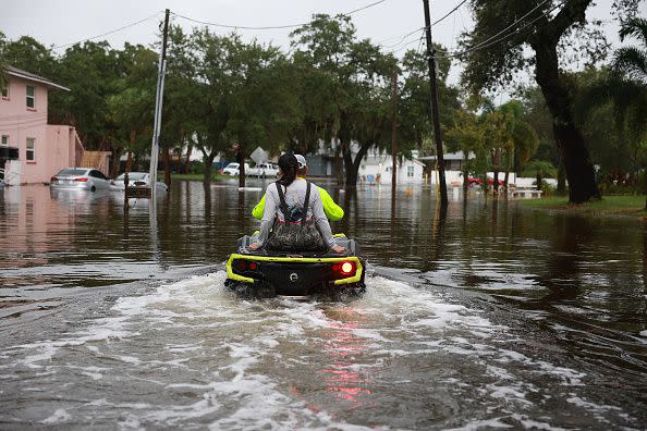 TARPON SPRINGS, FLORIDA - AUGUST 30: People ride an ATV through the flooded streets caused by Hurricane Idalia passing offshore on August 30, 2023 in Tarpon Springs, Florida. Hurricane Idalia is hitting the Big Bend area of Florida.  (Photo by Joe Raedle/Getty Images)