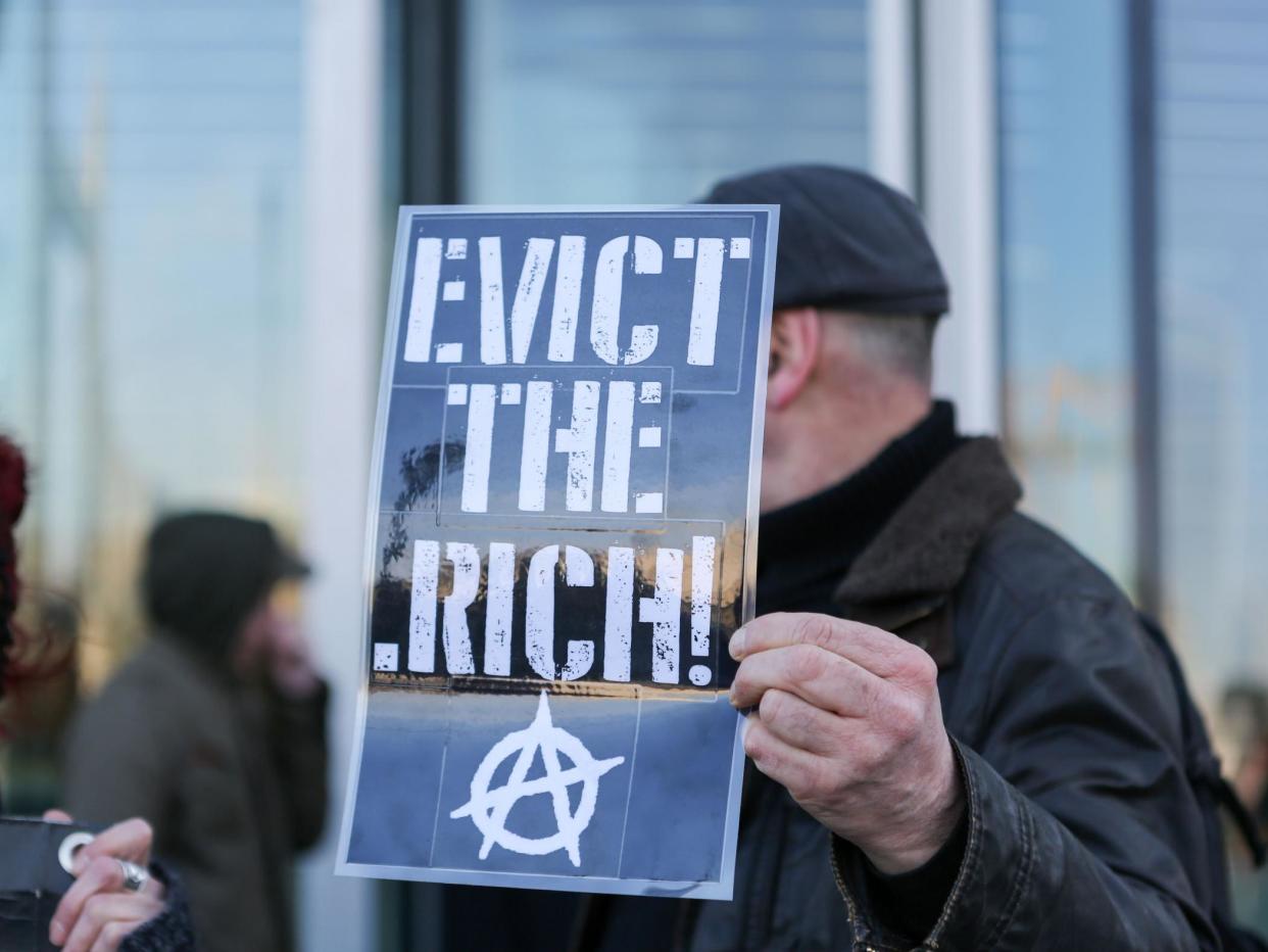 An anarchist holds aloft a placard at an anti-gentrification protest in London in 2018: Penelope Barritt/Shutterstock