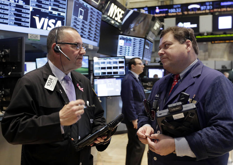 Traders John Yaccarine, left, an John Santiago work on the floor of the New York Stock Exchange, Tuesday, April 8, 2014. Stocks were mixed in early trading on Tuesday after a three-day slump. Investors will start to focus on company earnings this week. (AP Photo/Richard Drew)
