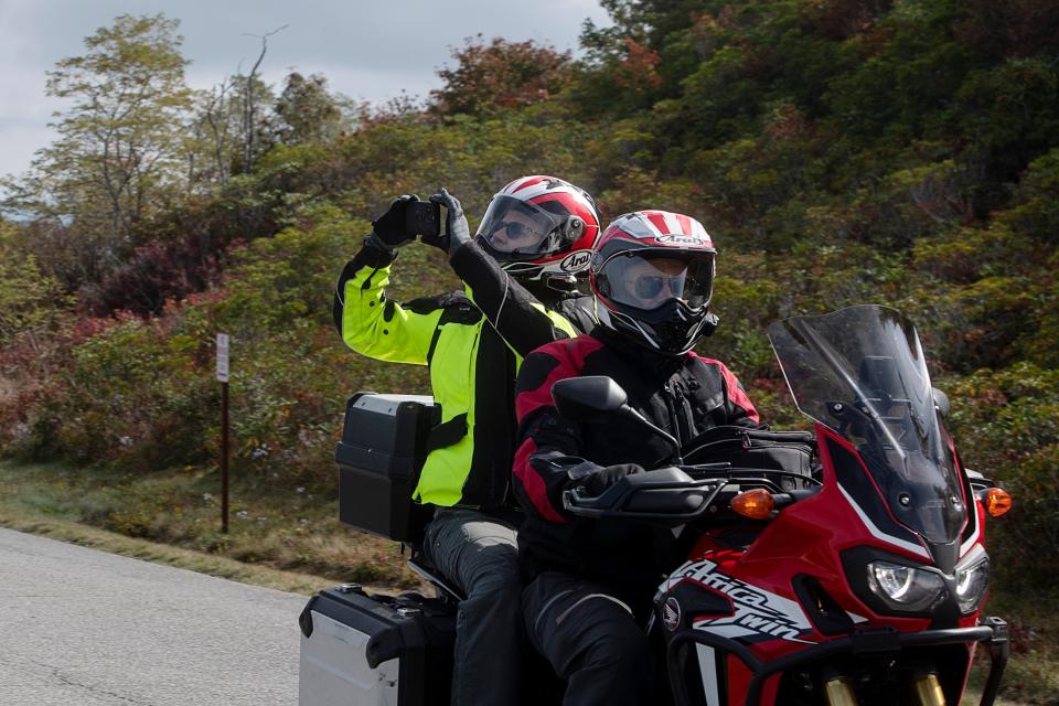 A motorcyclist’s passenger takes in the view from the Blue Ridge Parkway near Graveyard Fields, October 5, 2023.