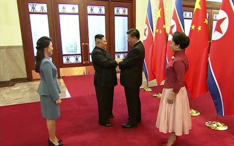 Kim Jong-un greets Chinese President Xi Jinping in the presence of their wives - Credit: CCTV/AFP