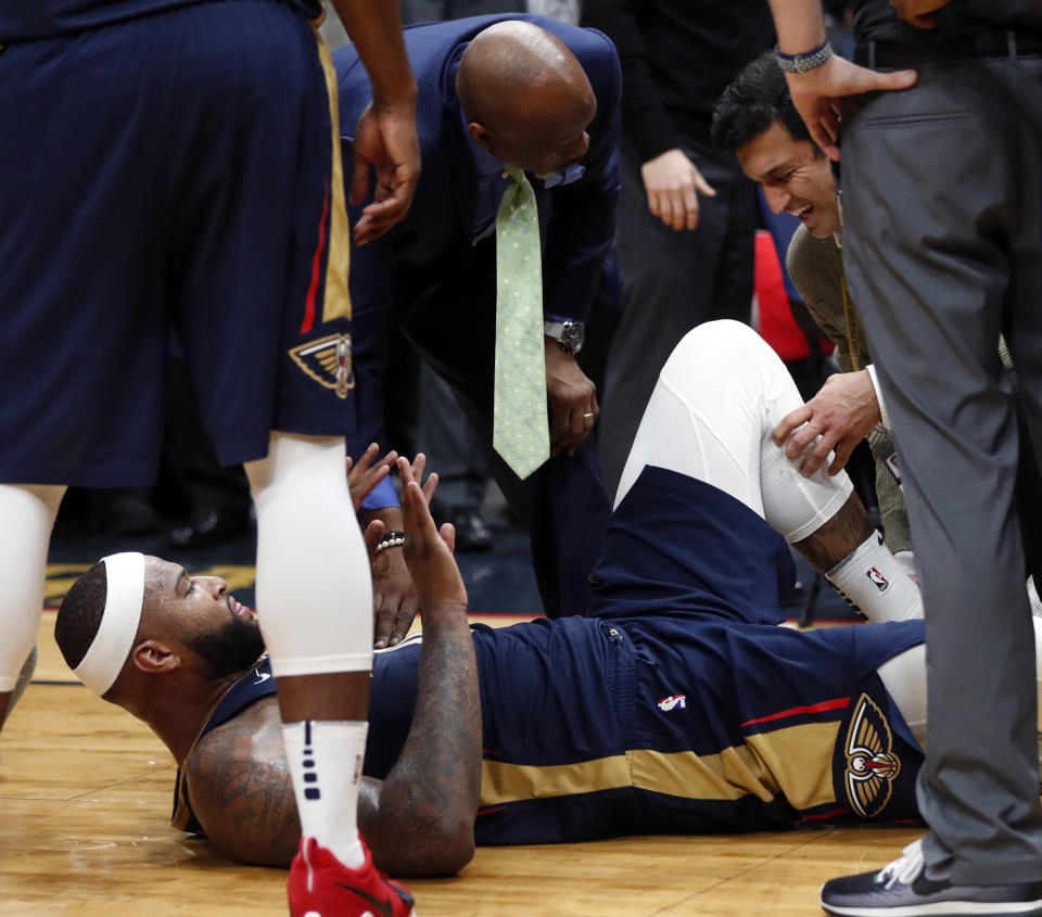 Pelicans center DeMarcus Cousins lies on the court while being tended to after injuring his left Achilles tendon Friday night. (AP)