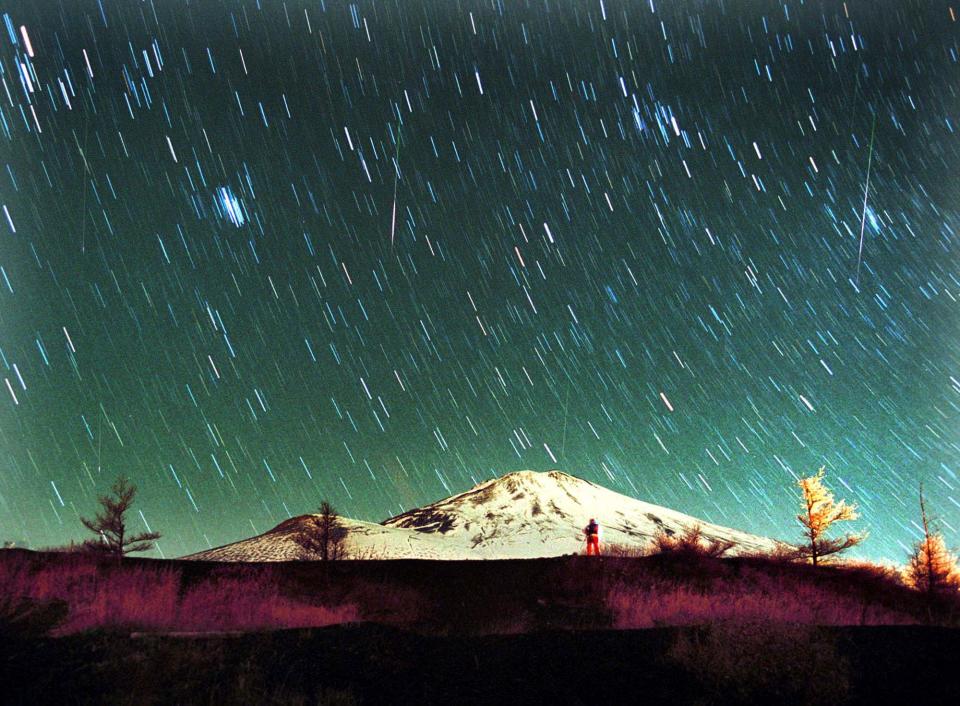 Leonid meteors are seen streaking across the sky over snow-capped Mount Fuji, Japan's highest mountain, early Monday Nov. 19, 2001, in this 7-minute exposure photo. Star gazers braved cold temperatures at the foot of Mount Fuji to observe the shower of Leonid meteors. (AP Photo/Itsuo Inouye)