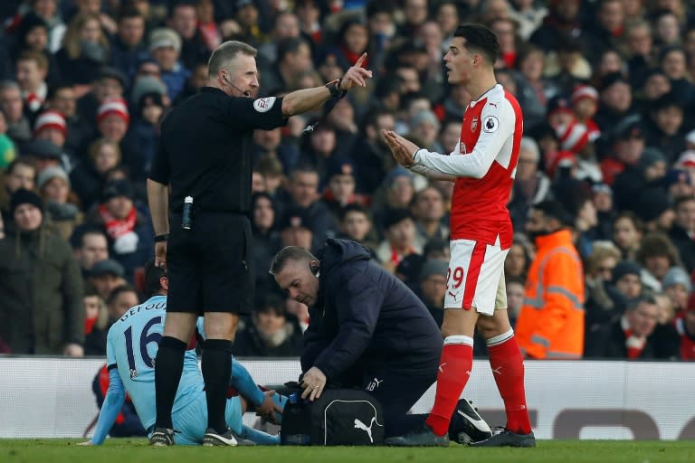 Referee Jonathan Moss (L) talks to Arsenal's Granit Xhaka during their English Premier League match against Burnley, at the Emirates Stadium in London, on January 22, 2017