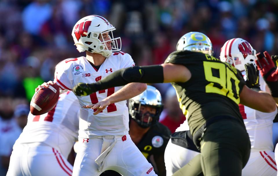 Jan 1, 2020; Pasadena, California, USA; Wisconsin Badgers quarterback Jack Coan (17) passes against Oregon Ducks defensive tackle Drayton Carlberg (90) in the first half during the 106th Rose Bowl game at Rose Bowl Stadium.