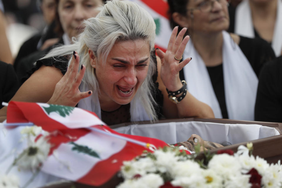 Lara, the wife of Alaa Abou Fakher who was killed by a Lebanese soldier on Tuesday night protests in southern Beirut, mourns over her husband's body during his funeral procession, in Choueifat neighborhood, Lebanon, Thursday, Nov. 14, 2019. For nearly a month, the popular protests engulfing Lebanon have been startlingly peaceful. But the death of Fakher, a 38-year-old father, by a soldier, the first such fatality in the unrest, points to the dangerous, dark turn the country could be heading into. (AP Photo/Hussein Malla)