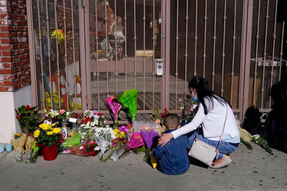 A woman comforts her son while visiting a makeshift memorial outside Star Dance Studio in Monterey Park, Calif., Monday, Jan. 23, 2023.