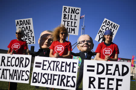 Protesters wearing giant puppet heads resembling Australian Prime Minister Scott Morrison and Australian Opposition Leader Bill Shorten are seen during a Stop Adani protest outside Parliament House in Canberra, Australia, February 12, 2019. Picture taken February 12, 2019. AAP Image/Lukas Coch/via REUTERS