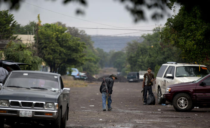 An armed man from the Self-Defense Council of Michoacan, (CAM), walks at a checkpoint set up by the self-defense group at the entrance to the town of Antunez, Mexico, Thursday, Jan. 16, 2014. Vigilantes in Michoacan state insist they won't lay down their guns until top leaders of a powerful drug cartel are arrested, defying government orders as federal forces try to regain control in a lawless region plagued by armed groups. (AP Photo/Eduardo Verdugo)